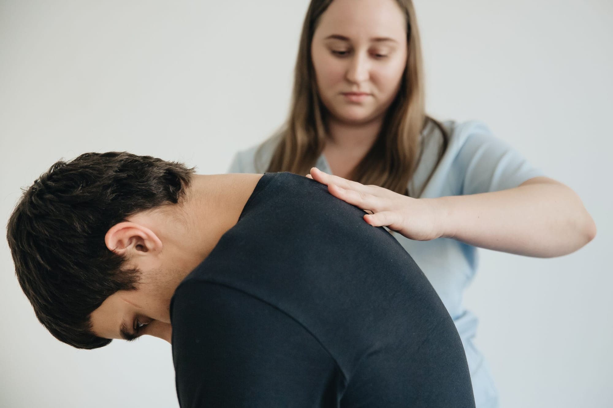 Illustration for Posture problems: physiotherapist checking a rounded upper back
